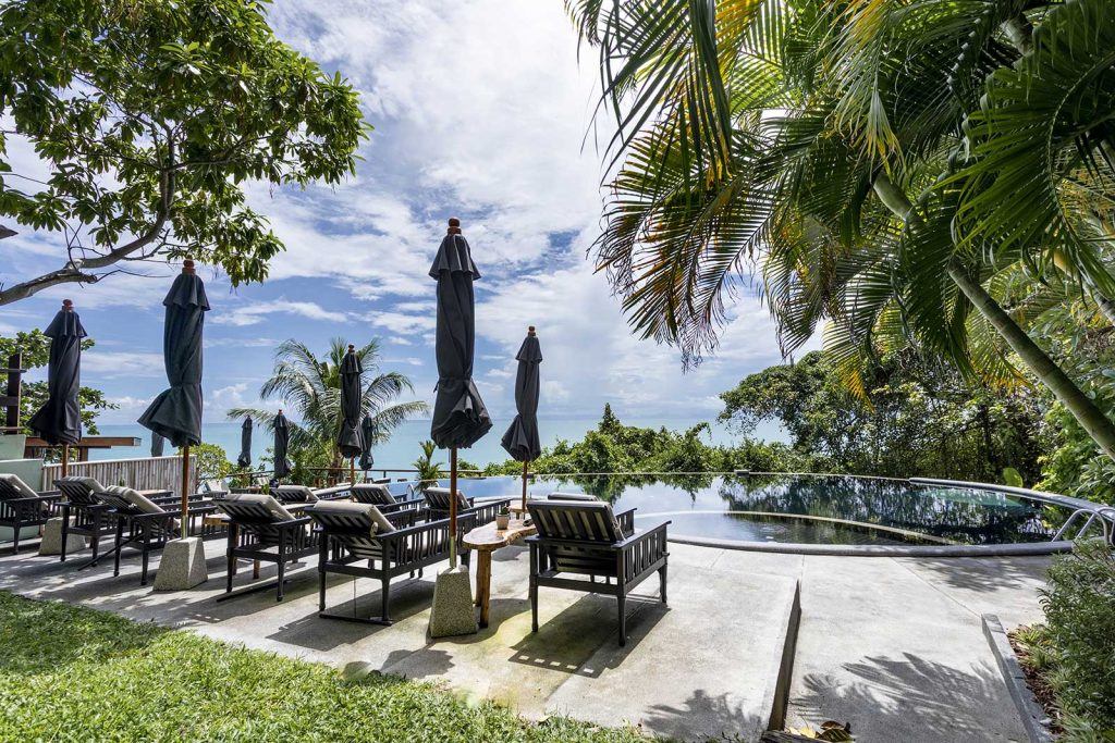 Chaises longues et piscine avec vue sur l’océan à Vikasa, Koh Samui